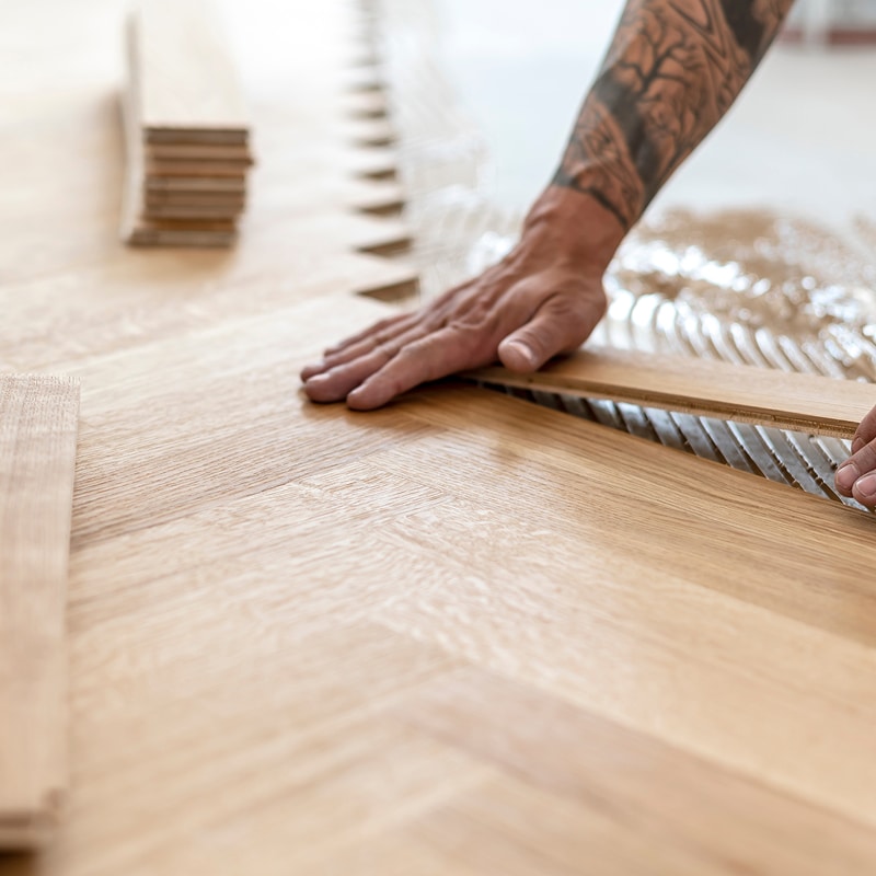 Peintre avec rouleau à peinture : préparation travaux Gros plan sur la main d'un peintre portant un gant blanc, tenant fermement le manche d'un rouleau à peinture neuf, en préparation d'une rénovation.