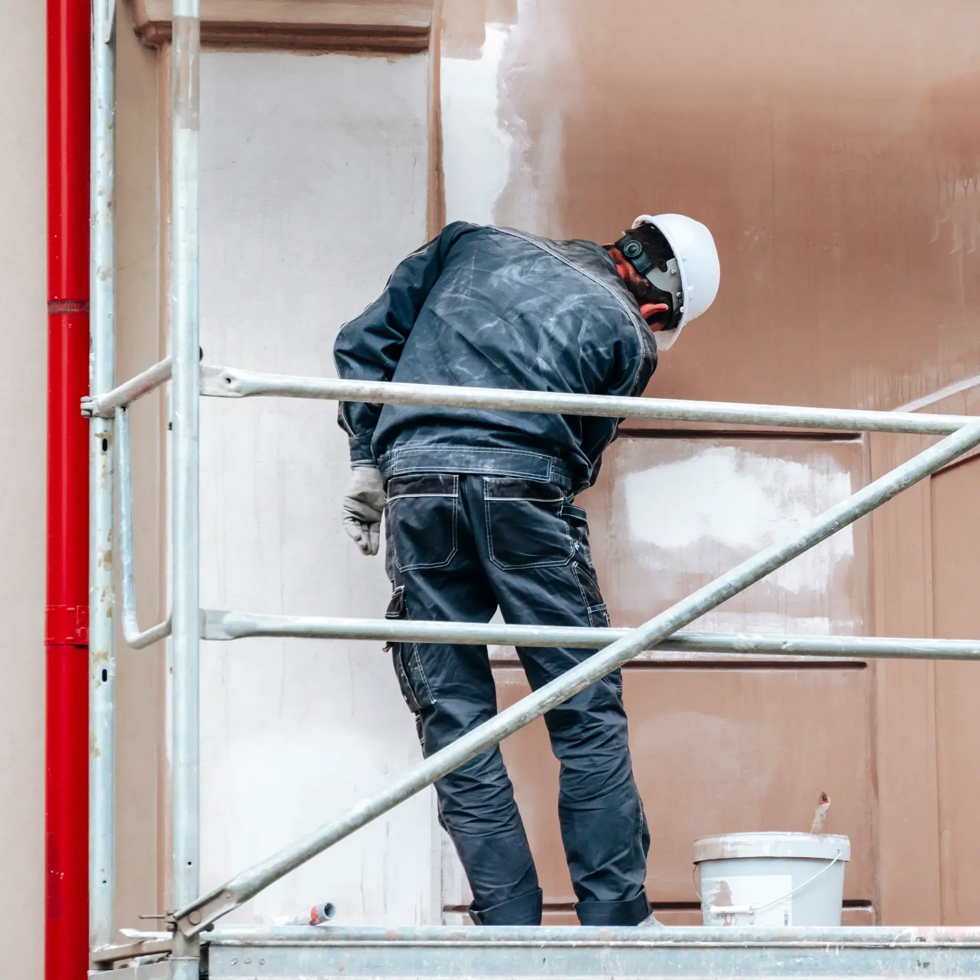 Peintre avec rouleau à peinture : préparation travaux Gros plan sur la main d'un peintre portant un gant blanc, tenant fermement le manche d'un rouleau à peinture neuf, en préparation d'une rénovation.